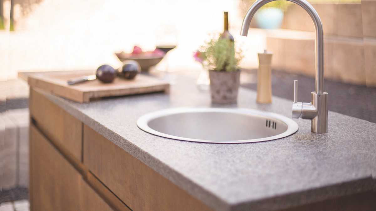 Ein integriertes Spülbecken erleichtert das Kochen im Freien. Gartenküche von Gartenmetall®, Modell ELBA, Spülbecken und Wasserhahn aus Edelstahl.