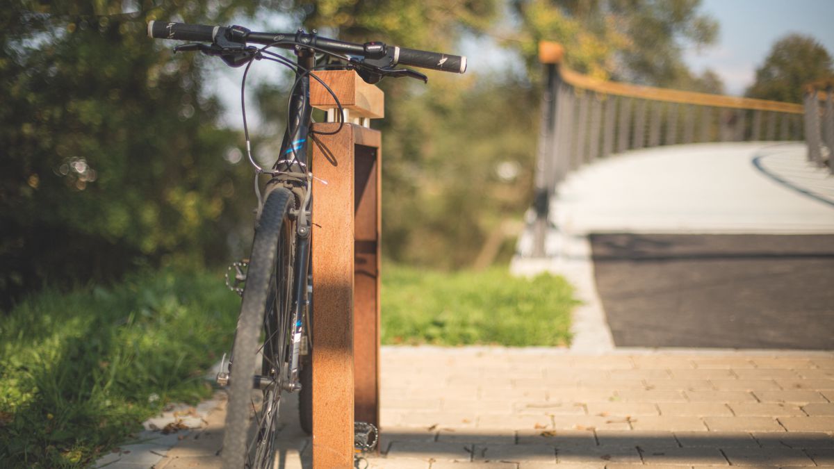 Fahrradparker Oldenburg aus Cortenstahl: Das Rad kann schonend am Holzbügel angelehnt und sicher abgeschlossen werden.